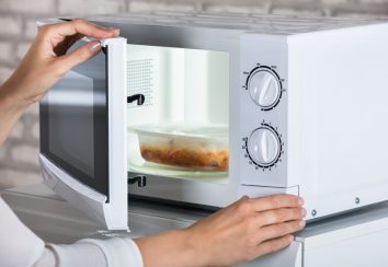 Woman's Hands Closing Microwave Oven Door And Preparing Food At Home